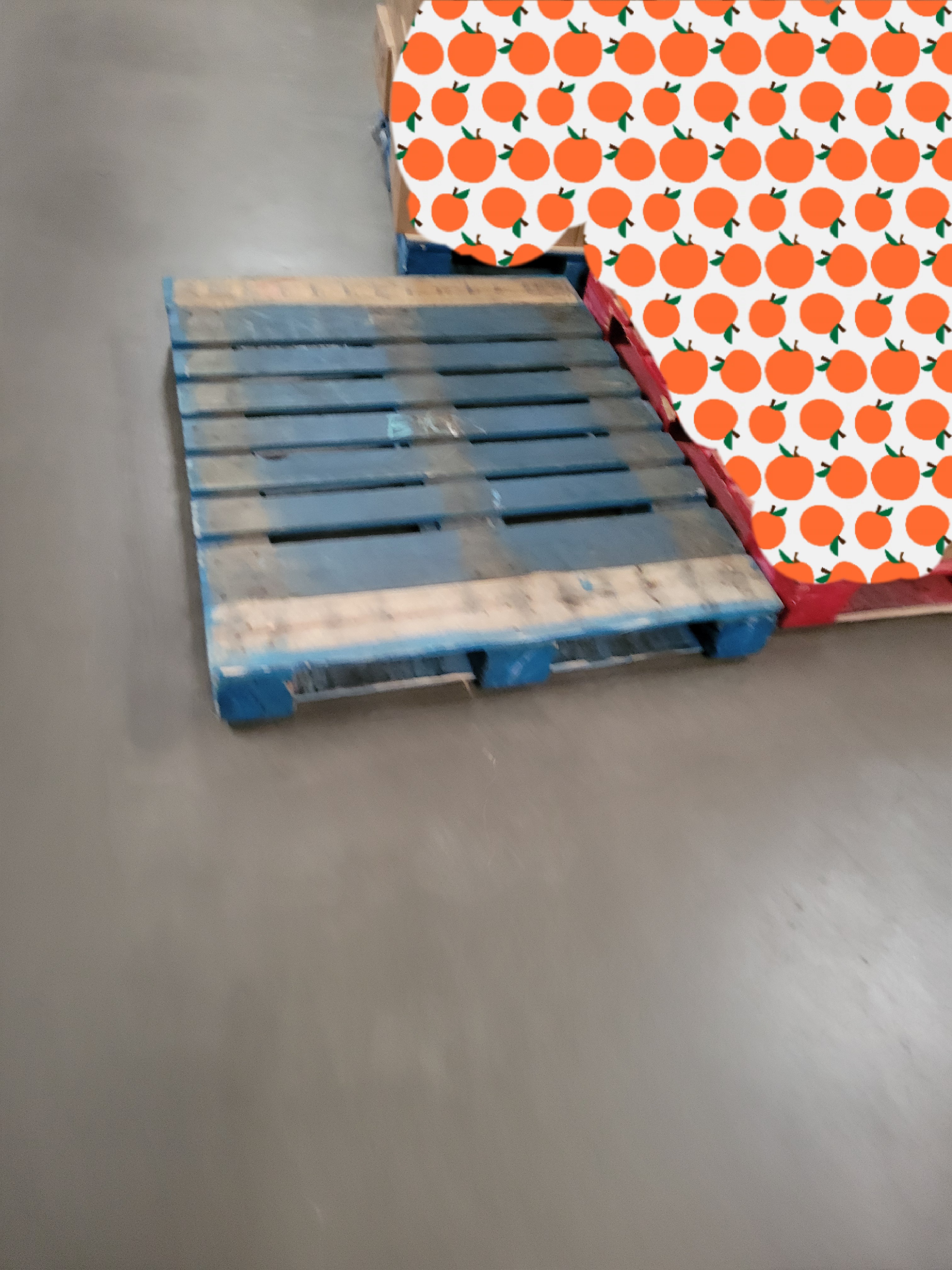 Empty pallet next to two cardboard box filled ones.